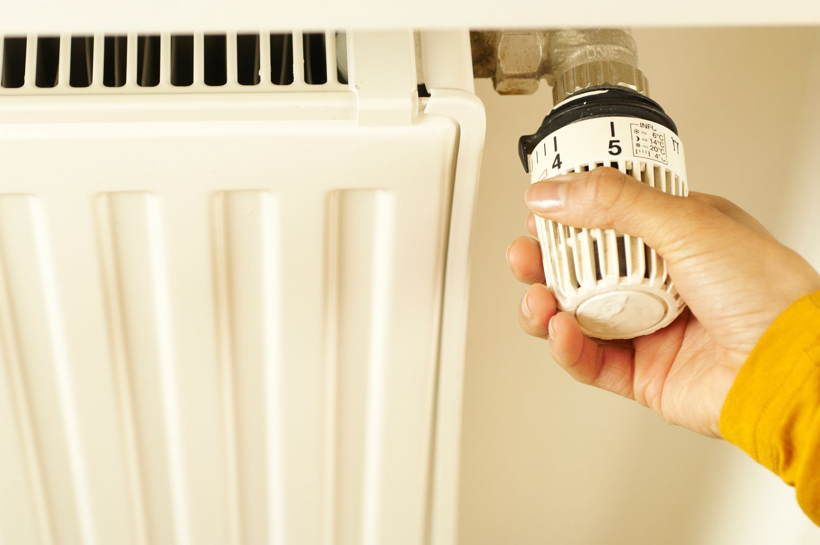 Radiator valve – licensed stock Hand adjusting a radiator valve